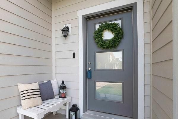 Modern gray door and porch on home with vinyl siding