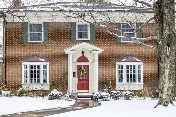 Traditional brick home with covered porch and shutters